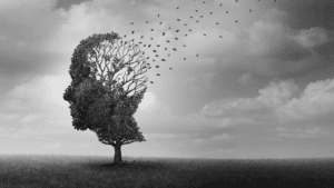 tree in shape of a head with leaves blowing away